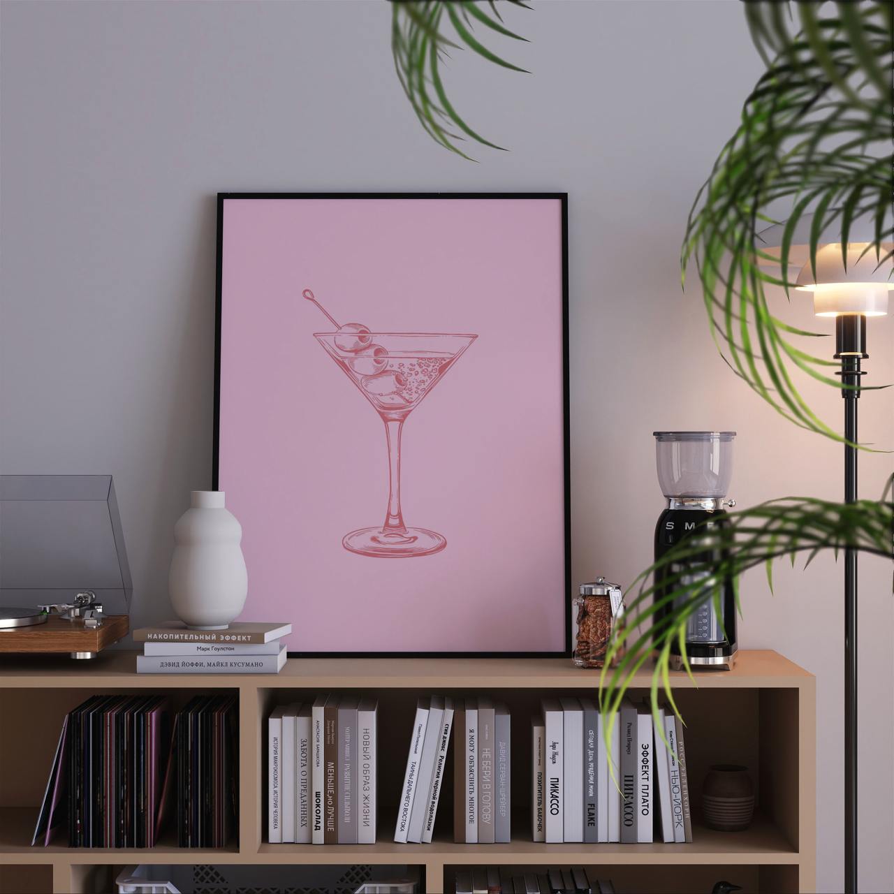 Bookshelf with a pink poster of a cocktail, books, and decorative items.