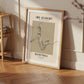 Framed poster of a basketball player on a wooden floor with a shelf in the background
