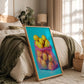 Framed artwork of lemons in a colorful vase on a bed in a bedroom.