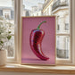 Framed artwork of a pink mosaic pepper on a windowsill with a cityscape background