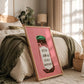 Framed artwork with text on a bed in a bedroom setting