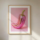 Framed artwork of a pink and gold chili pepper on a pink background