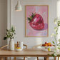 Dining room with a pink disco strawberry artwork on the wall, wooden table, and fruit display.