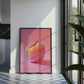 Framed artwork of a fruit on a pink background in a modern kitchen.