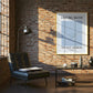 Modern living room with a brick wall, sofa, coffee table, and framed poster.