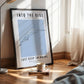 Framed poster with 'Into the Blue' and 'Just Keep Swimming' text in a room with a lamp and cup.