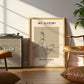 Framed artwork of a woman playing basketball in a living room with a Marshall amplifier and brown chair.