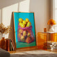 Framed artwork of lemons in a bag on a table with a lamp and books in a room.