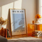 Framed poster with 'Into the Blue' and 'Just Keep Swimming' text in a room with decor elements.