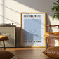 Framed poster with 'Chasing Water, Just Keep Swimming' text in a living room setting.