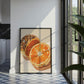 Framed artwork of oranges and a loaf of bread on a wall in a modern kitchen.