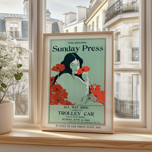 The image features a framed vintage poster advertising the 'Philadelphia Sunday Press,' with a soft color palette and stylized artwork ty
pical of the late 19th and early 20th centuries