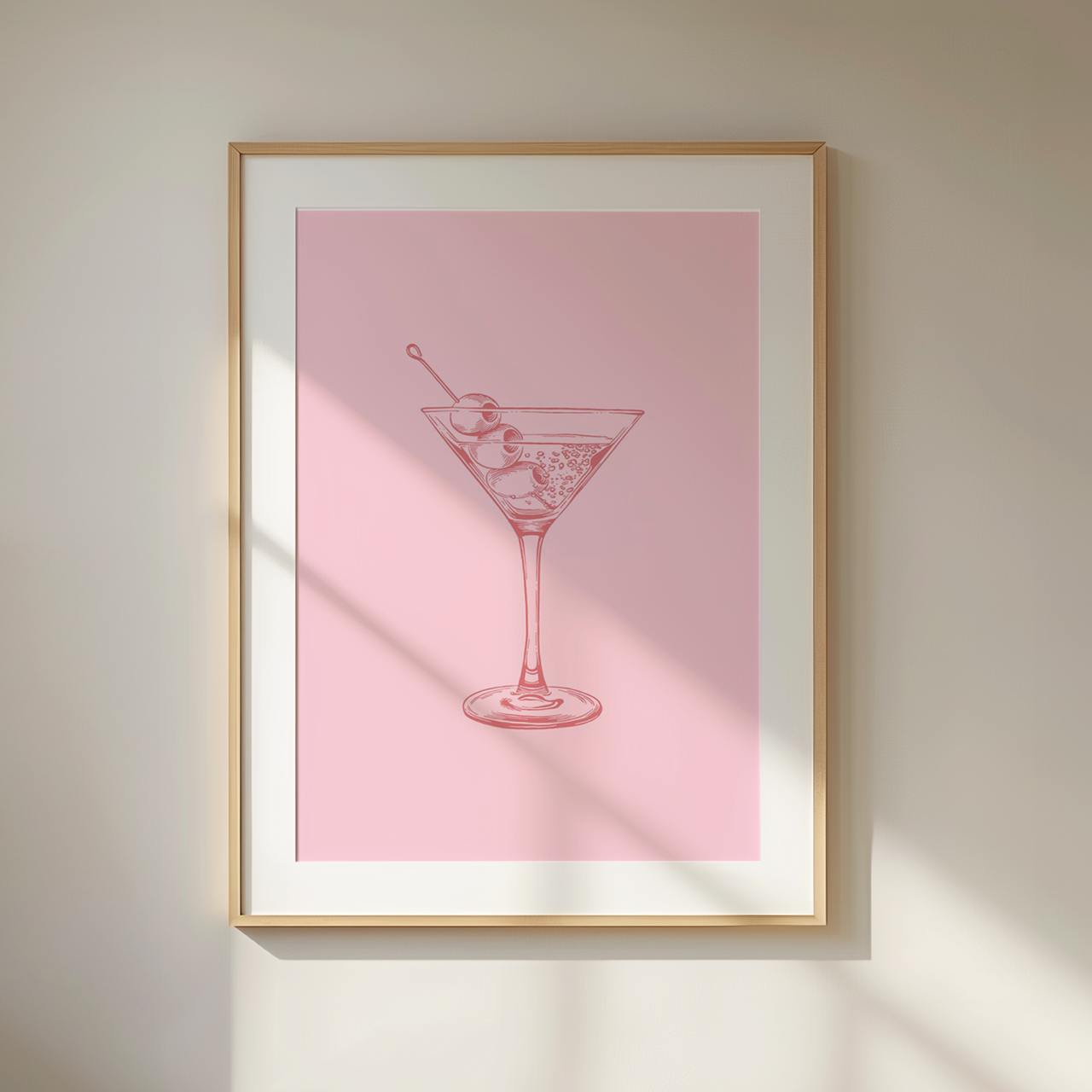 Framed artwork of a martini glass on a pink background
