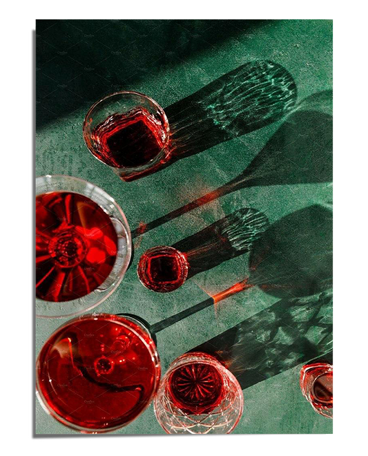 A collection of wine glasses filled with deep red liquid casting elongated shadows and reflections on a textured green surface. The interplay of light creates a dramatic and sophisticated visual effect.