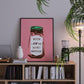 Framed artwork with a pink background and text on a shelf with books and decor items.