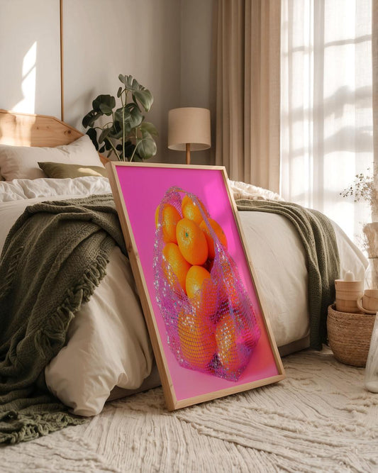 Framed artwork of oranges on a bed in a bedroom