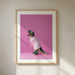 Framed artwork of a dinosaur in a robe on a pink background