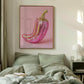 Framed artwork of a pink and gold chili pepper above a bed in a bedroom.