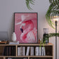 Framed artwork of a pink flamingo wearing a cowboy hat on a shelf with books and decor.